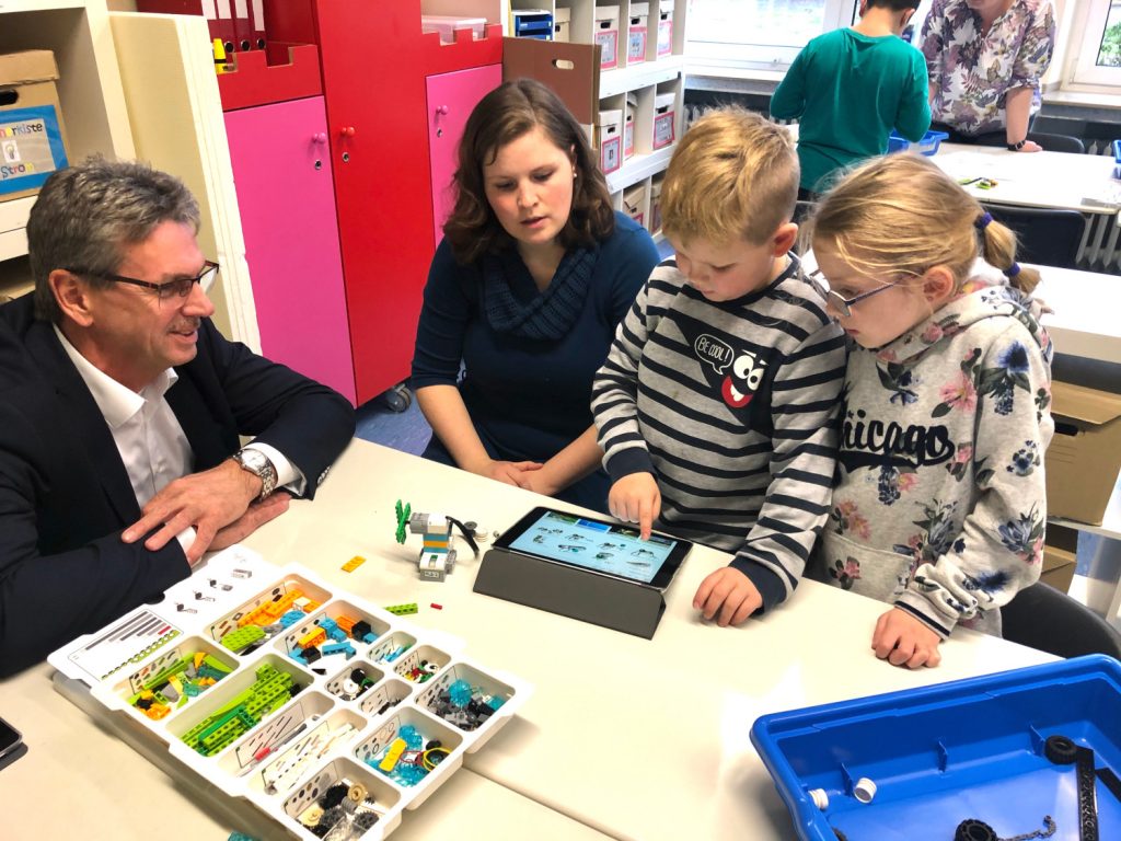 Ralph Hackelbörger, Ausbildungsleiter bei der Gea, (v.l.) lässt sich von Nina Wiesrecker, Leon und Estelle erklären, wie die Software funktioniert